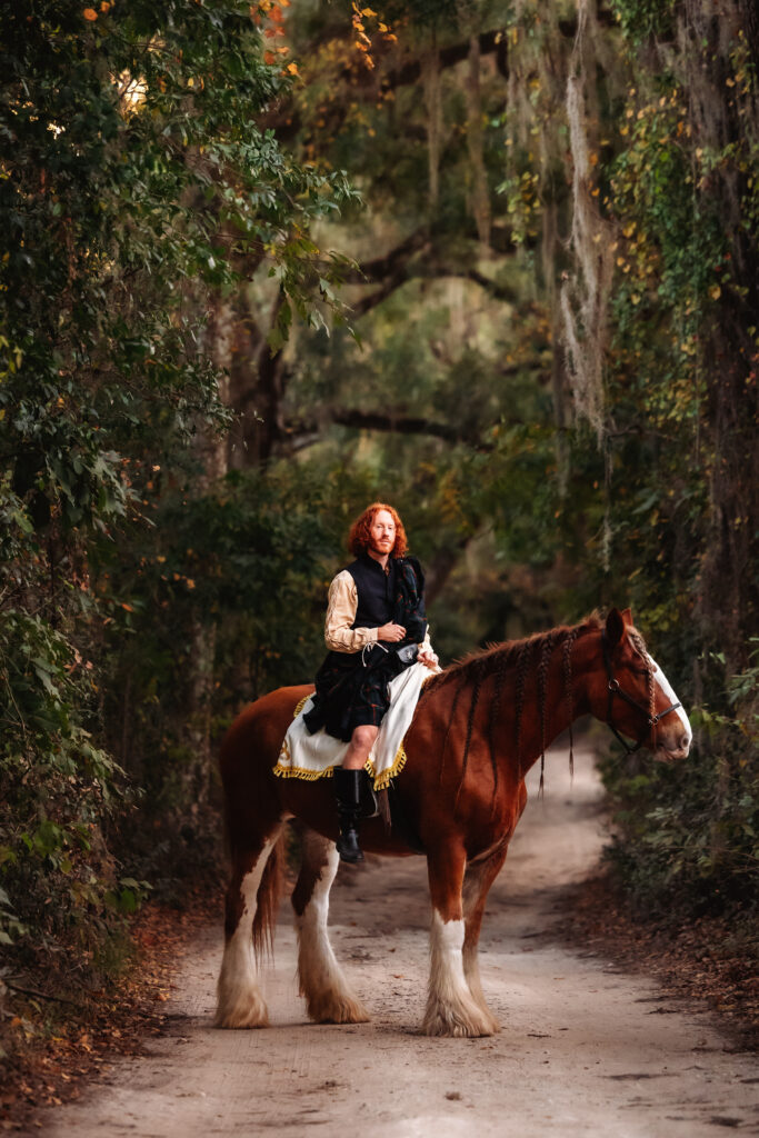A couple eloped in Florida and embraces a unique adventure, with the bride riding a horse through a scenic woodland path in a vintage-style black gown.