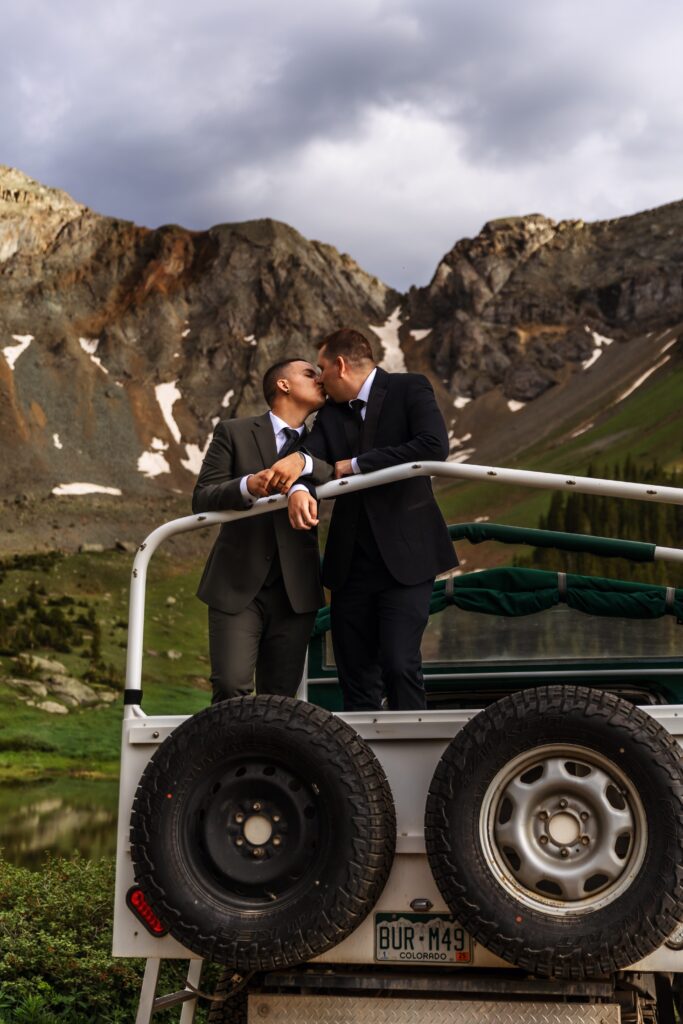 A couple kisses on top of a 4x4 vehicle during their colorado adventure elopement