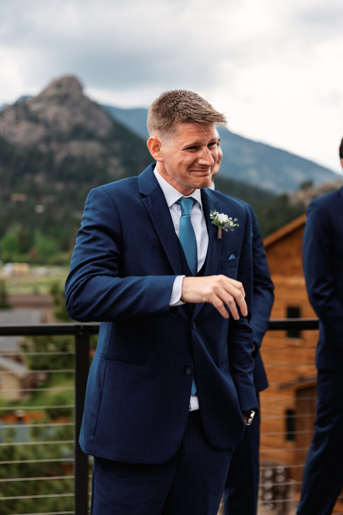 A groom tears up as he watches his partner walk down the aisle for their Estes Park elopement in Colorado.