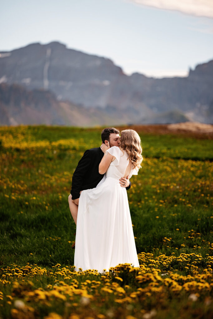 Couple kissing in dandelion field during Telluride Elopement, Colorado