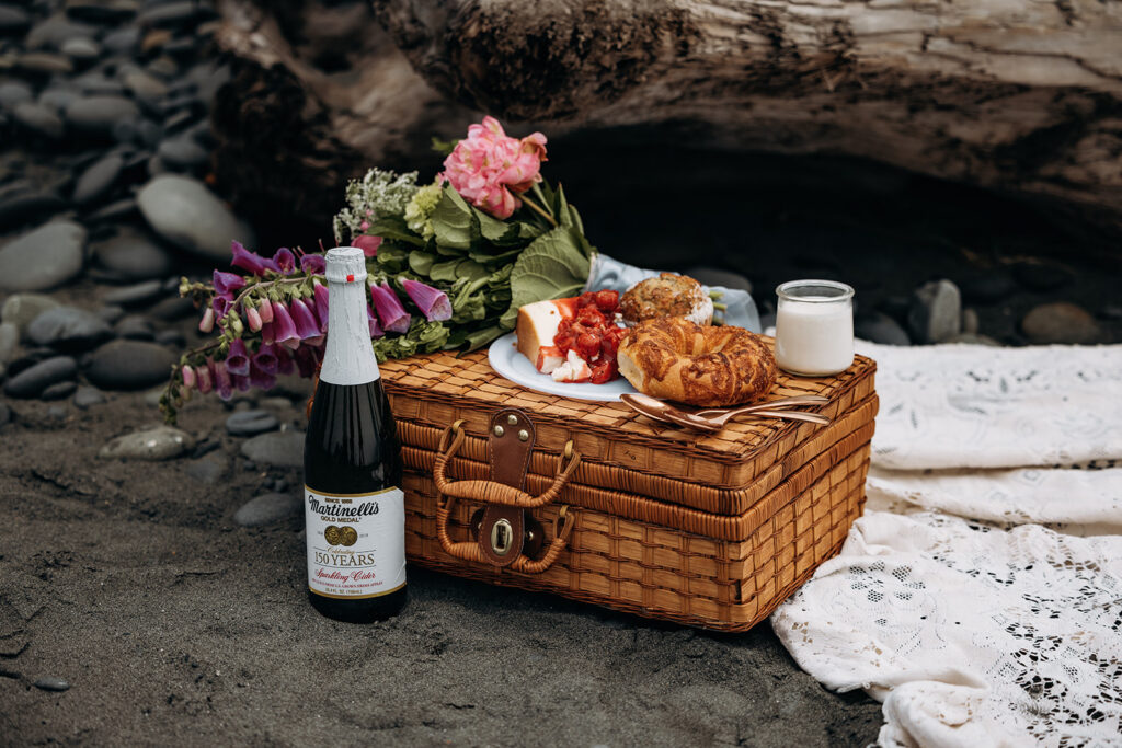 Picnic basket with sparkling cider and pastries during Ruby Beach Elopement, Olympic National Park, Washington