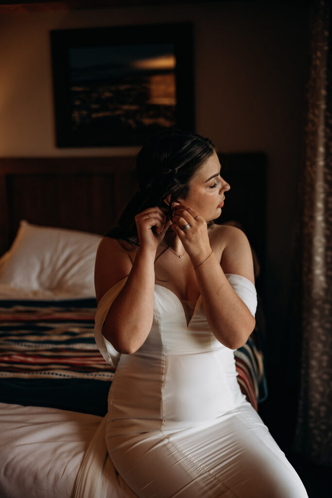 Bride putting on earring getting ready at Kalaloch Lodge for Ruby Beach Elopement, Olympic National Park, Washington