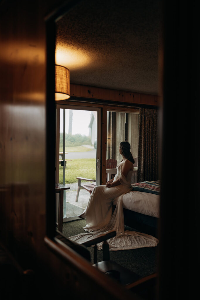 Bride sitting on bed getting ready at Kalaloch Lodge for Ruby Beach Elopement, Olympic National Park, Washington